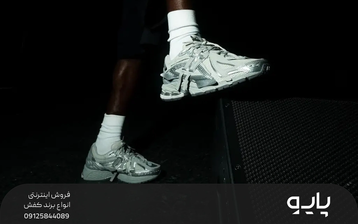 فردی که کفش های نقره ای نیوبالانس پوشیده و از پله بالا می رود